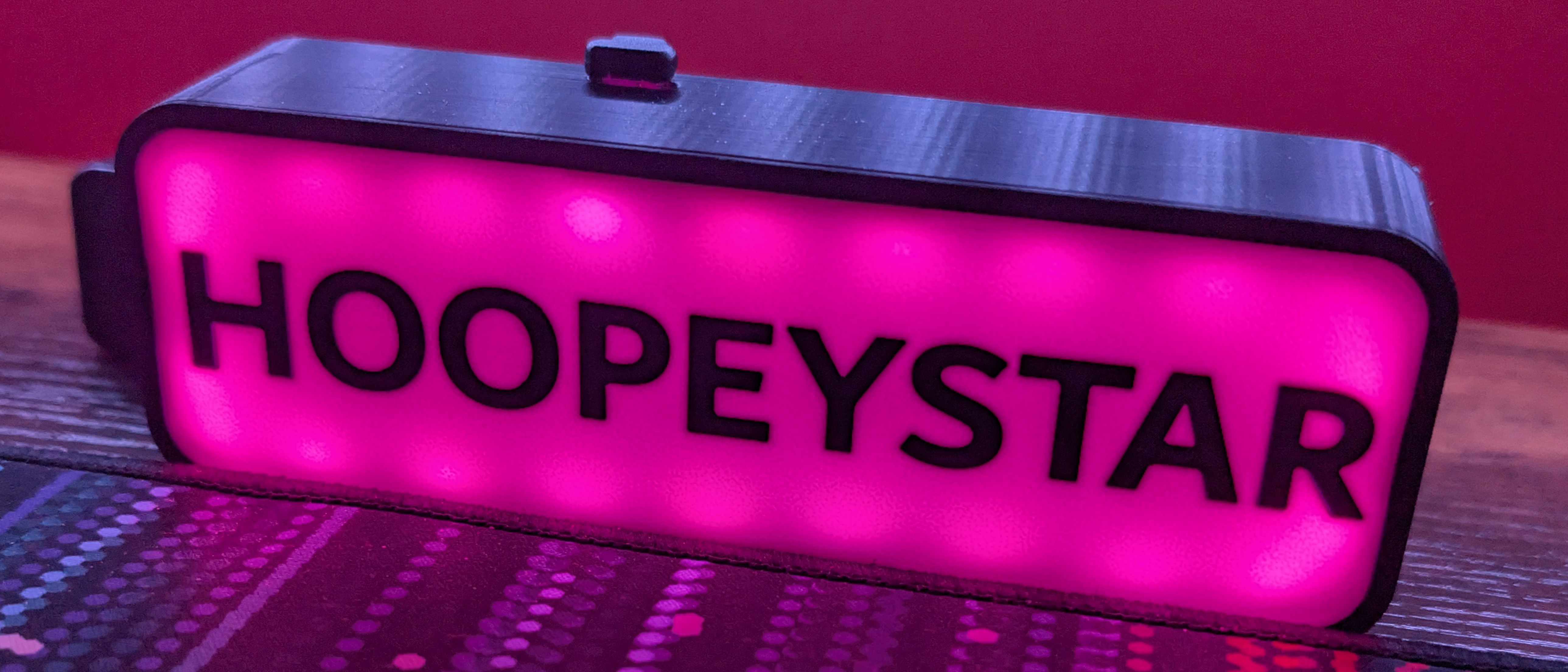 Pink Hoopeystar LED sign on a desk